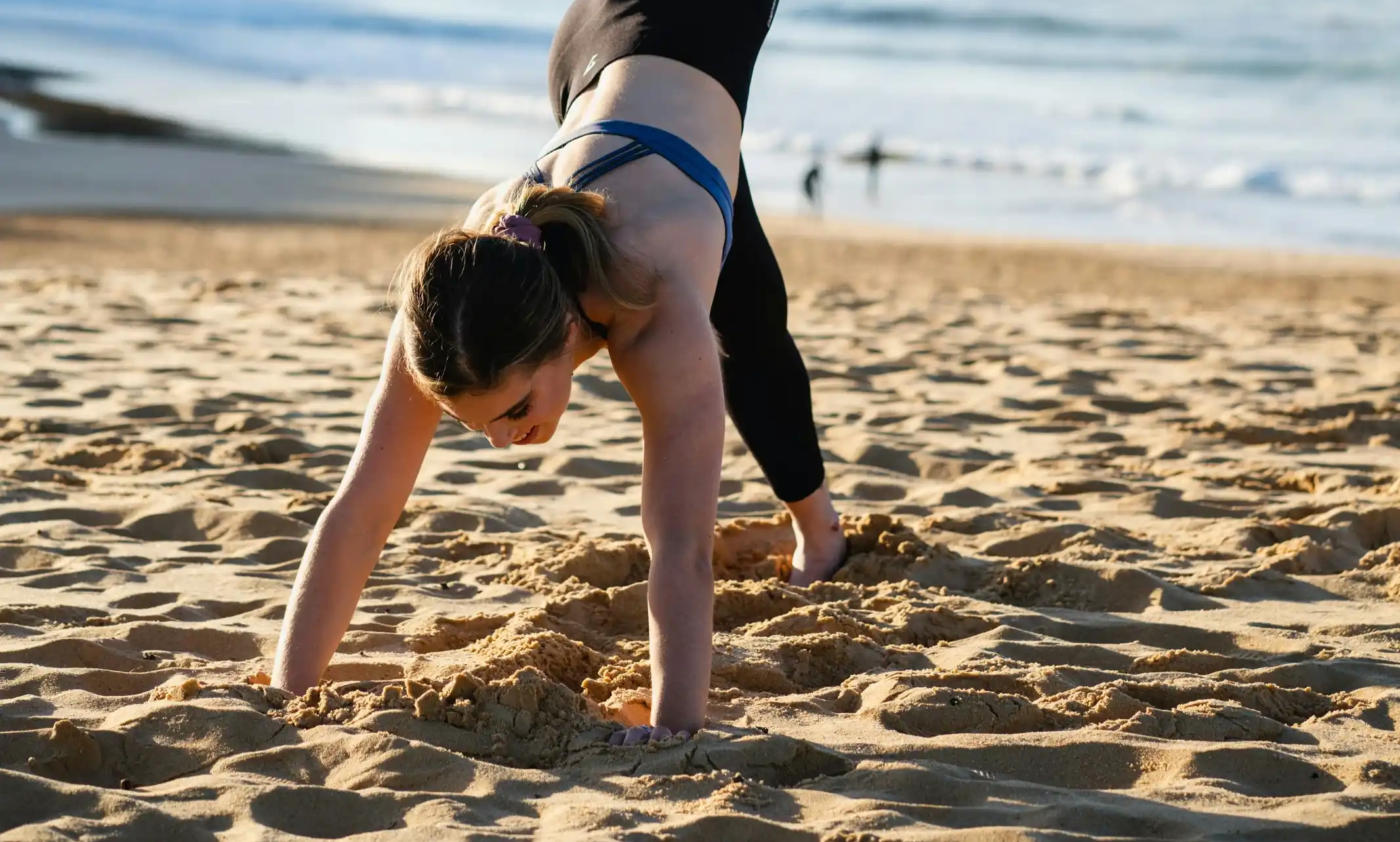 A woman doing a handstand on the beach